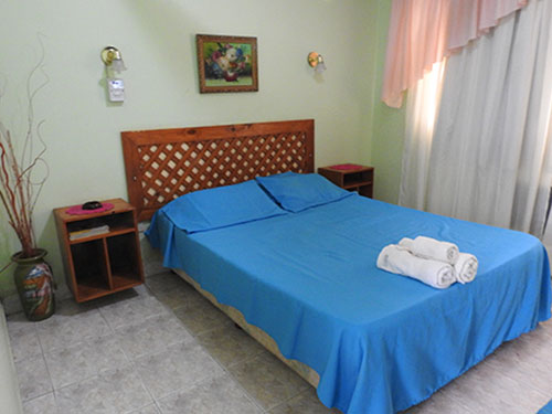Habitación matrimonial con cama doble y ropa blanca